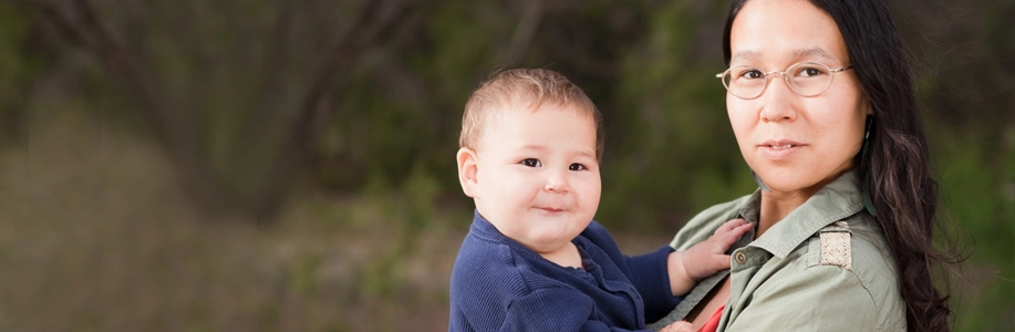 Asian mother and baby look at camera
