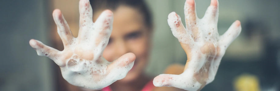 Person holds up soapy hands